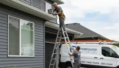 Technician performing vinyl siding and gutter inspection on Columbus, OH home exterior