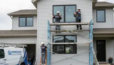 Technician repairing house window frame and glass in Columbus, OH for Next Level Exteriors